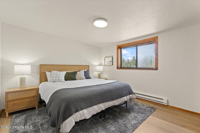 400 S Ohana Beach Dr, Coeur Dalene, ID 83814 - bedroom featuring a baseboard radiator and wood finished floors