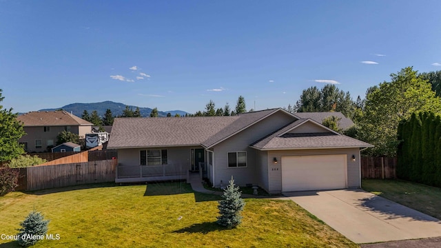 208 Brittany Loop, Sandpoint, ID 83864 - ranch-style house with a garage, concrete driveway, a mountain view, and a shingled roof
