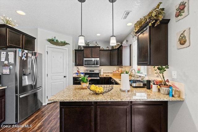 838 W Jenicek Loop, Post Falls, ID 83854 - kitchen featuring stainless steel appliances, dark brown cabinetry, dark wood-style floors, a peninsula, and light stone counters
