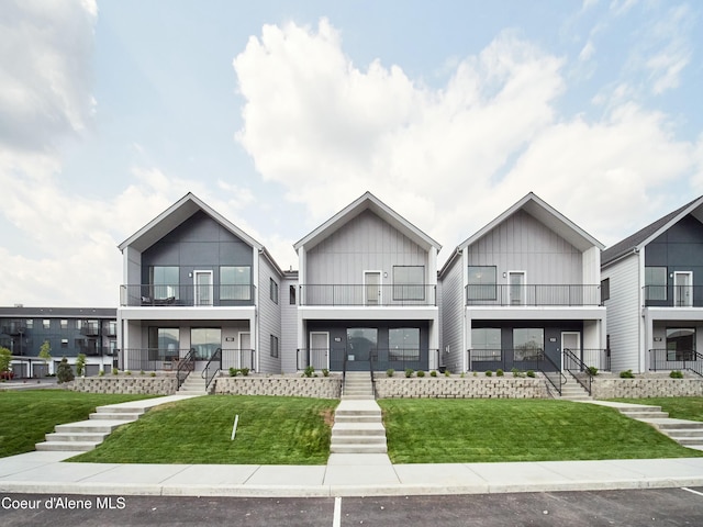 953 E Railroad Ave, Post Falls, ID 83854 - modern home with a balcony, board and batten siding, a front lawn, and stairway