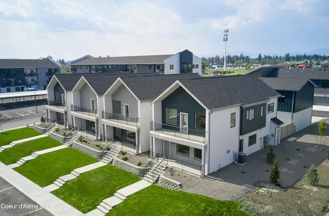 953 E Railroad Ave, Post Falls, ID 83854 - view of front of home featuring a shingled roof, a balcony, board and batten siding, and a front yard