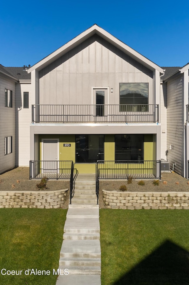 993 E Railroad Ave, Post Falls, ID 83854 - view of front of home with a balcony, a front yard, board and batten siding, and a porch