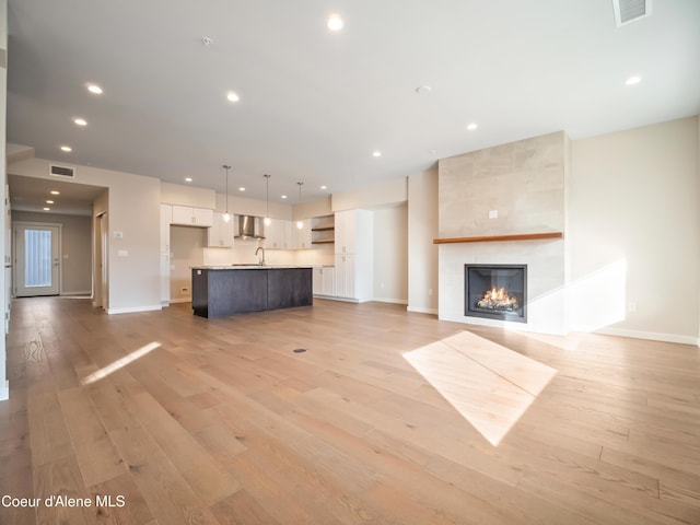 993 E Railroad Ave, Post Falls, ID 83854 - unfurnished living room with light wood-type flooring, recessed lighting, and a tiled fireplace