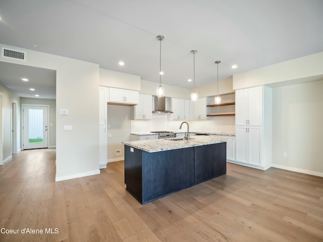 993 E Railroad Ave, Post Falls, ID 83854 - kitchen with wall chimney range hood, white cabinetry, light wood-style floors, open shelves, and decorative light fixtures