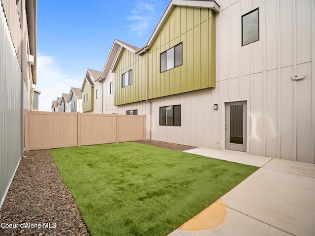 993 E Railroad Ave, Post Falls, ID 83854 - rear view of house featuring board and batten siding, a fenced backyard, and a patio area