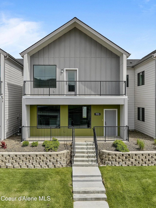 995 E Railroad Ave, Post Falls, ID 83854 - view of front facade featuring a balcony, board and batten siding, a front yard, and covered porch