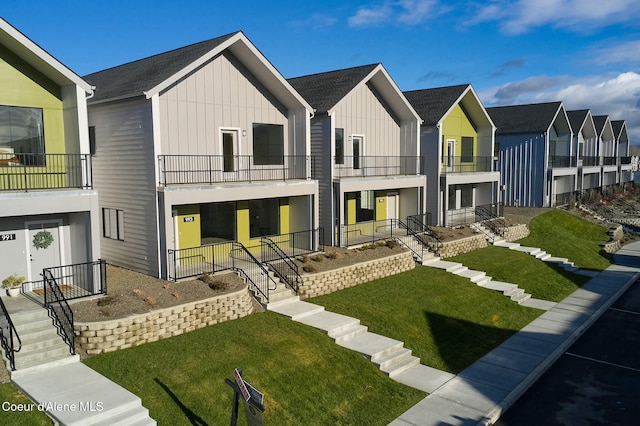 995 E Railroad Ave, Post Falls, ID 83854 - view of front of property with a balcony, board and batten siding, a front lawn, a residential view, and a porch