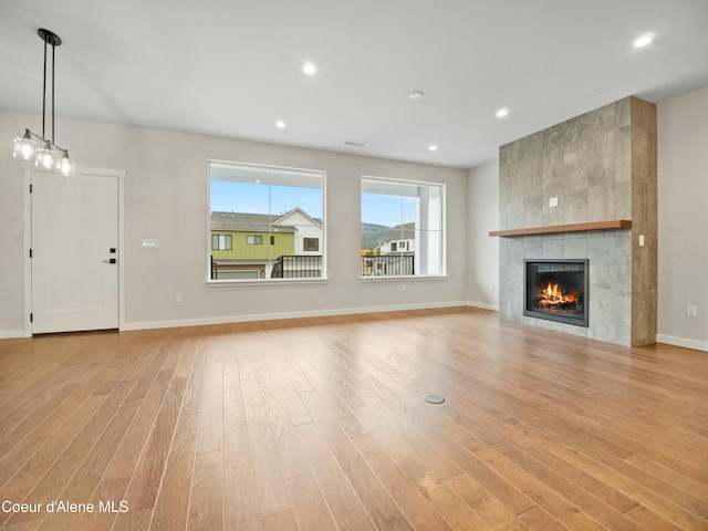995 E Railroad Ave, Post Falls, ID 83854 - unfurnished living room with light wood-type flooring, a tile fireplace, and recessed lighting
