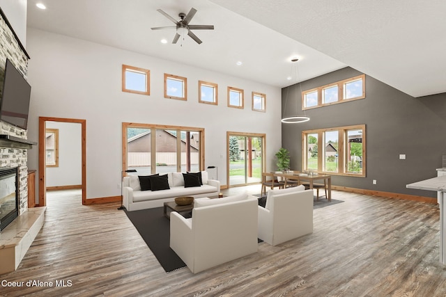 24 Bellflower, Blanchard, ID 83804 - living room with a stone fireplace, a towering ceiling, light wood-type flooring, a ceiling fan, and recessed lighting