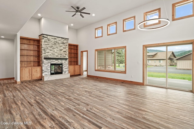 24 Bellflower, Blanchard, ID 83804 - unfurnished living room with wood finished floors, recessed lighting, ceiling fan, a high ceiling, and a fireplace