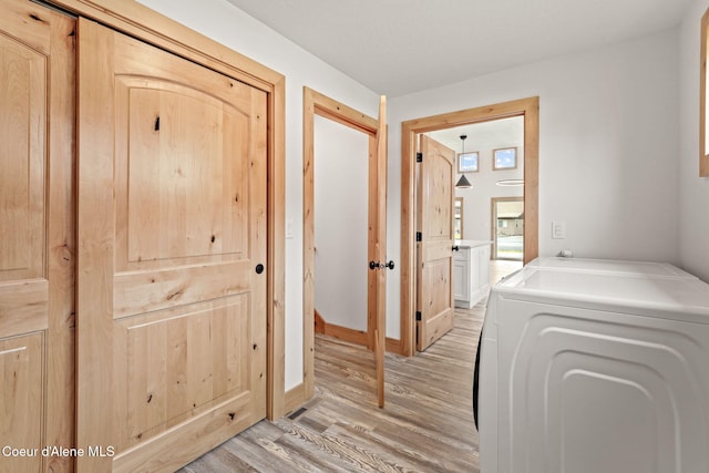 24 Bellflower, Blanchard, ID 83804 - hallway featuring washer / dryer and light wood-style flooring