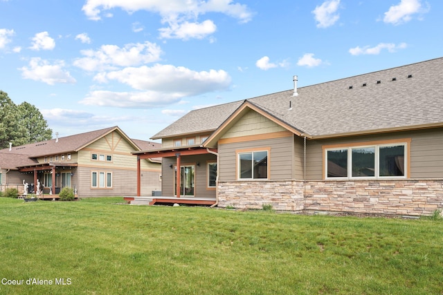24 Bellflower, Blanchard, ID 83804 - view of front of property with a wooden deck, stone siding, a front yard, and a shingled roof