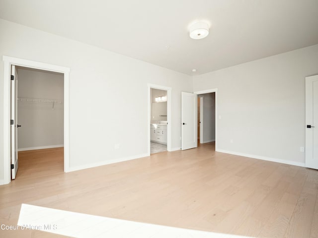 1033 E Railroad Ave, Post Falls, ID 83854 - unfurnished bedroom featuring light wood finished floors, a walk in closet, and ensuite bath