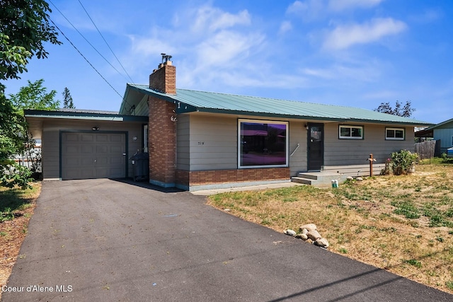 59 W Lincoln Ave, Priest River, ID 83856 - single story home with a chimney, driveway, a garage, a metal roof, and brick siding