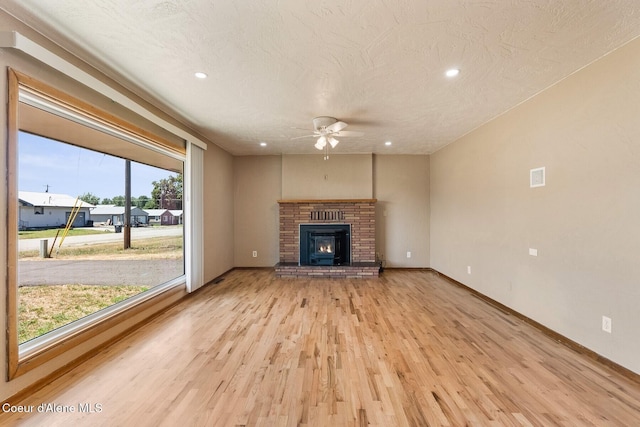 59 W Lincoln Ave, Priest River, ID 83856 - unfurnished living room featuring a ceiling fan, light wood finished floors, recessed lighting, a fireplace, and a textured ceiling