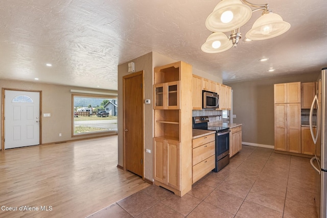 59 W Lincoln Ave, Priest River, ID 83856 - kitchen with stainless steel appliances, light brown cabinetry, a textured ceiling, recessed lighting, and a chandelier