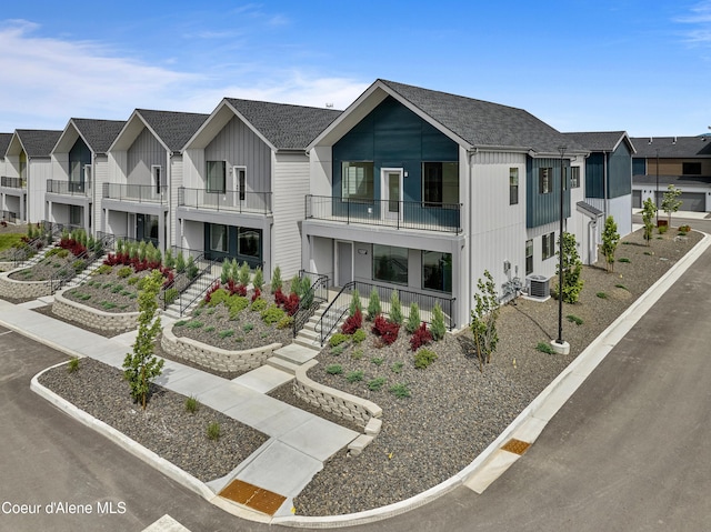 1037 E Railroad Ave, Post Falls, ID 83854 - modern farmhouse style home featuring a balcony, stairway, a residential view, and board and batten siding