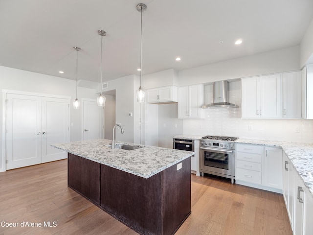 1037 E Railroad Ave, Post Falls, ID 83854 - kitchen with wall chimney range hood, high end stove, light wood-style flooring, white cabinetry, and recessed lighting