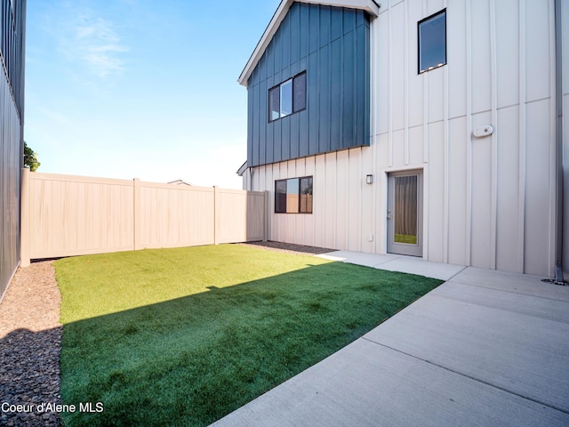1037 E Railroad Ave, Post Falls, ID 83854 - back of property with board and batten siding, a fenced backyard, and a patio