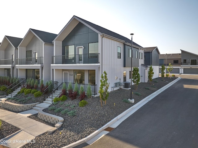 1037 E Railroad Ave, Post Falls, ID 83854 - view of front facade with board and batten siding, stairs, a balcony, and covered porch