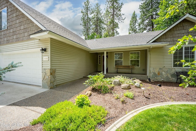 5188 E Twila Ct, Post Falls, ID 83854 - ranch-style house featuring a shingled roof, driveway, stone siding, and a garage
