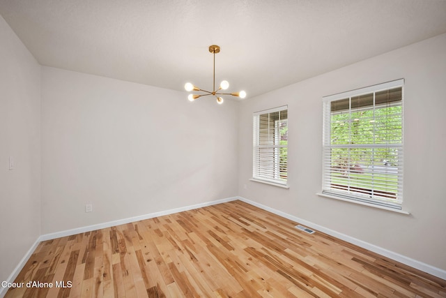 5188 E Twila Ct, Post Falls, ID 83854 - empty room with a chandelier and light wood-style flooring