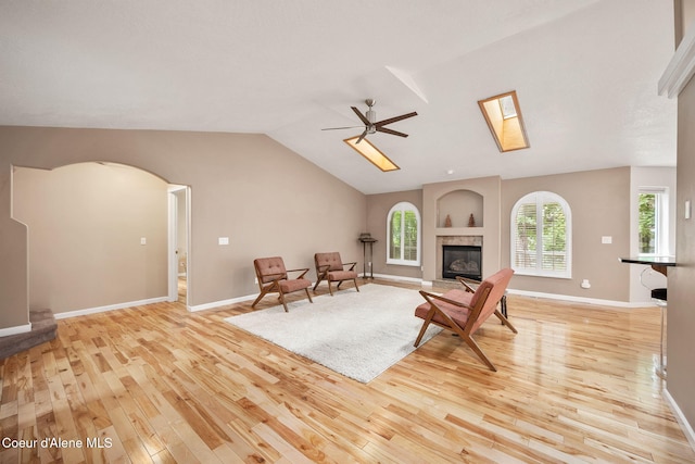 5188 E Twila Ct, Post Falls, ID 83854 - living room featuring light wood finished floors, vaulted ceiling, a ceiling fan, arched walkways, and a tile fireplace