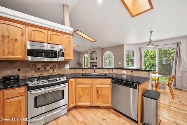 5188 E Twila Ct, Post Falls, ID 83854 - kitchen with stainless steel appliances, lofted ceiling, light wood-type flooring, tasteful backsplash, and a peninsula