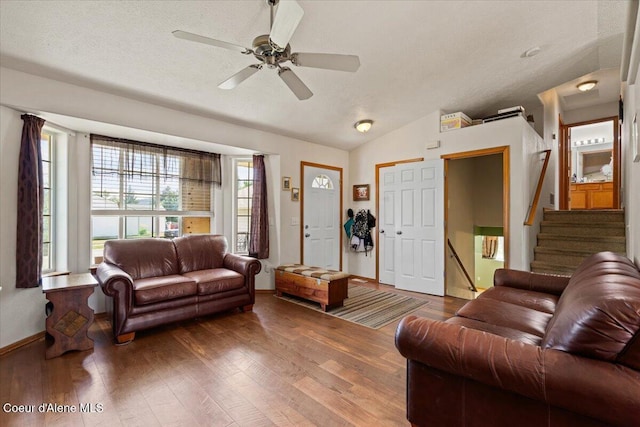 3569 E Jordan Dr, Post Falls, ID 83854 - living area with lofted ceiling, wood finished floors, ceiling fan, stairway, and a textured ceiling