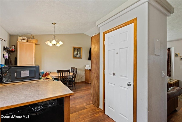 3569 E Jordan Dr, Post Falls, ID 83854 - kitchen with black appliances, a chandelier, dark wood-style floors, lofted ceiling, and a textured ceiling