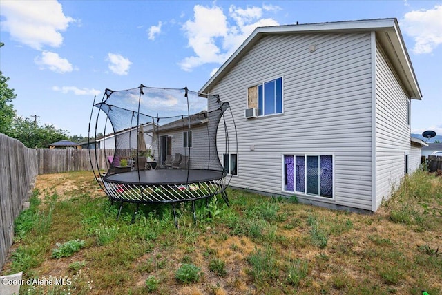 3569 E Jordan Dr, Post Falls, ID 83854 - rear view of house with a trampoline and a fenced backyard