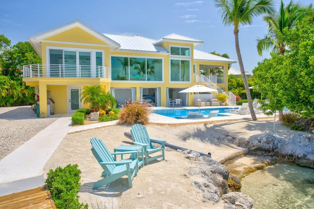 rear view of house featuring a balcony and a patio area