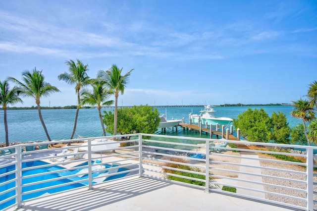 balcony with a water view and a dock