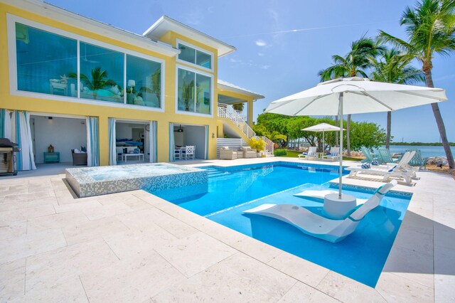 view of pool with a patio area and an in ground hot tub