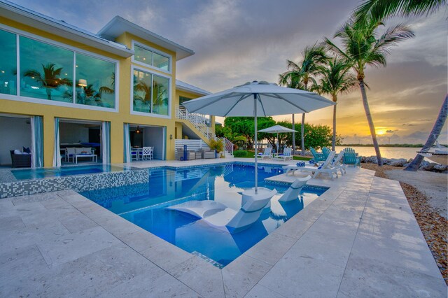 pool at dusk featuring a patio area