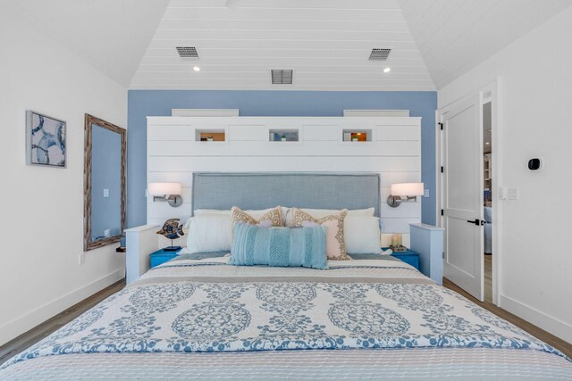 bedroom featuring lofted ceiling and hardwood / wood-style floors