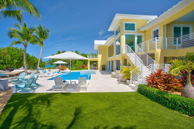 view of pool with a patio area and a lawn