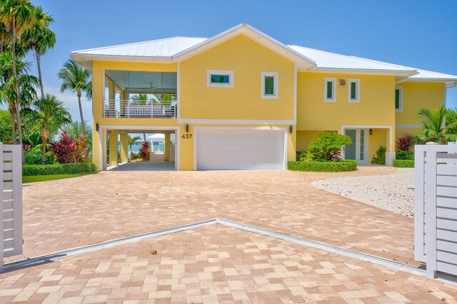 coastal inspired home with a garage and a balcony