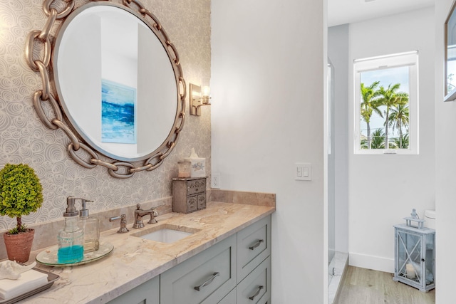 bathroom with hardwood / wood-style flooring, vanity, and a shower