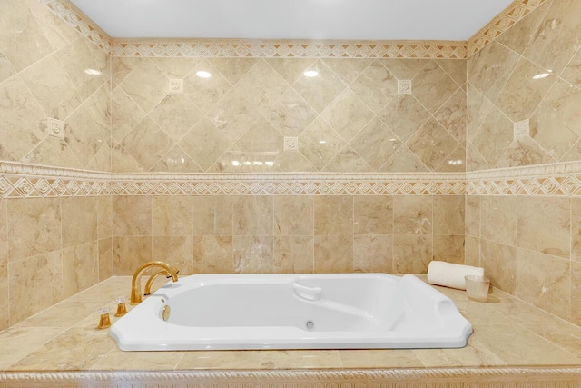 bathroom featuring tile walls and a garden tub