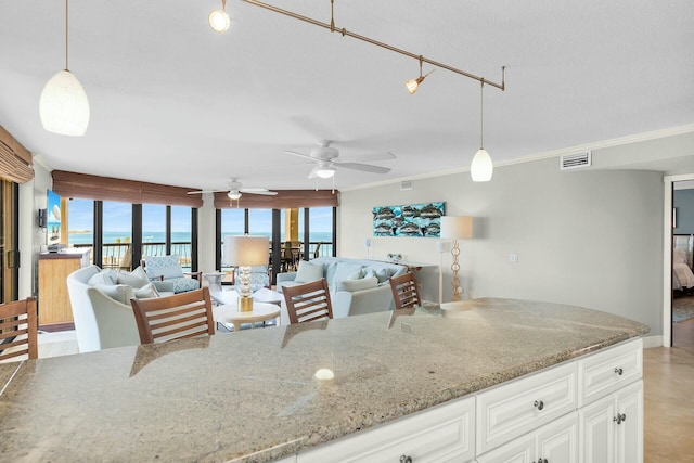 kitchen with a water view, visible vents, pendant lighting, and plenty of natural light
