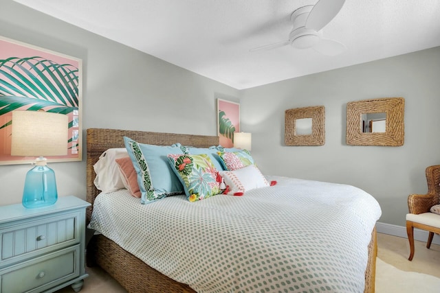 bedroom featuring ceiling fan, light carpet, and baseboards