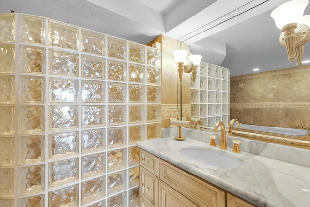full bath featuring a walk in shower, vanity, and tile walls
