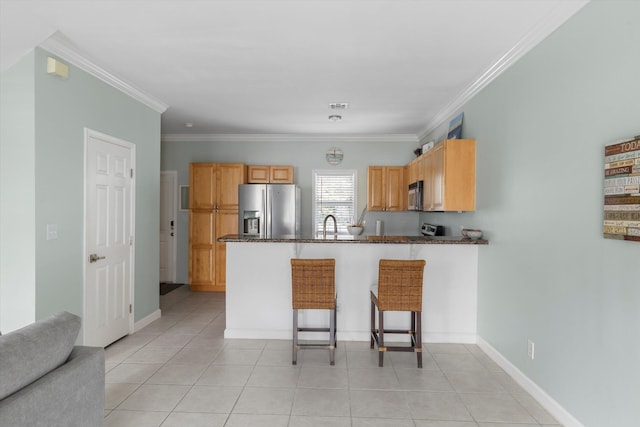 kitchen featuring a breakfast bar, crown molding, light tile patterned floors, appliances with stainless steel finishes, and kitchen peninsula