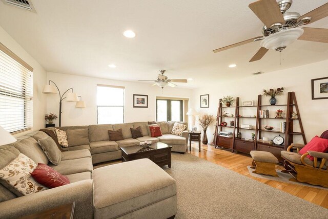 living room featuring light hardwood / wood-style floors and ceiling fan