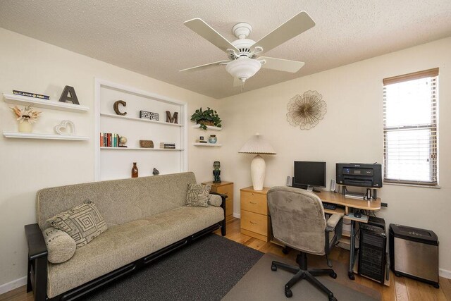 office featuring ceiling fan, light hardwood / wood-style floors, and a textured ceiling