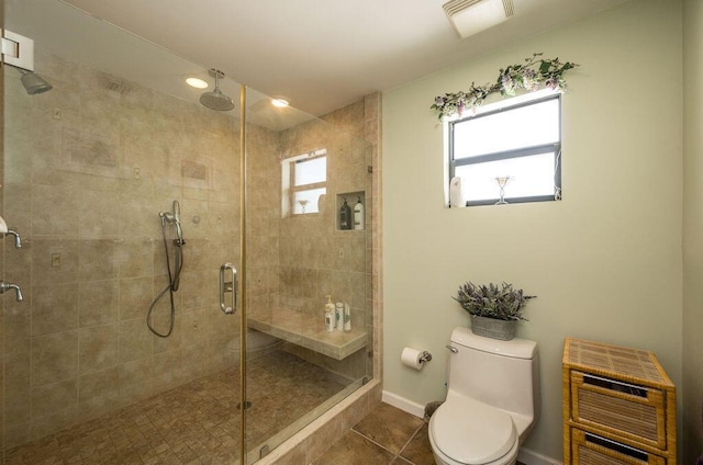 bathroom featuring tile patterned flooring, walk in shower, a healthy amount of sunlight, and toilet