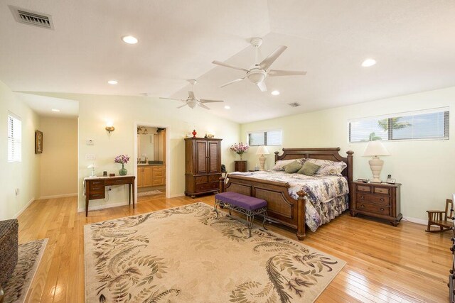 bedroom with lofted ceiling, ensuite bath, ceiling fan, and light hardwood / wood-style flooring