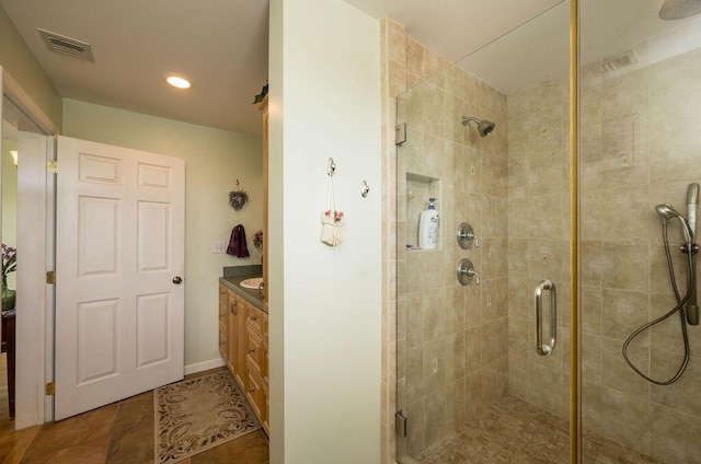 bathroom featuring walk in shower, vanity, and tile patterned flooring