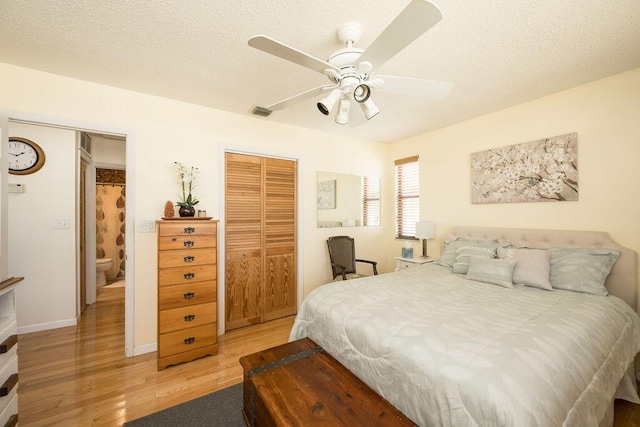 bedroom featuring ceiling fan, a closet, a textured ceiling, and light wood-type flooring